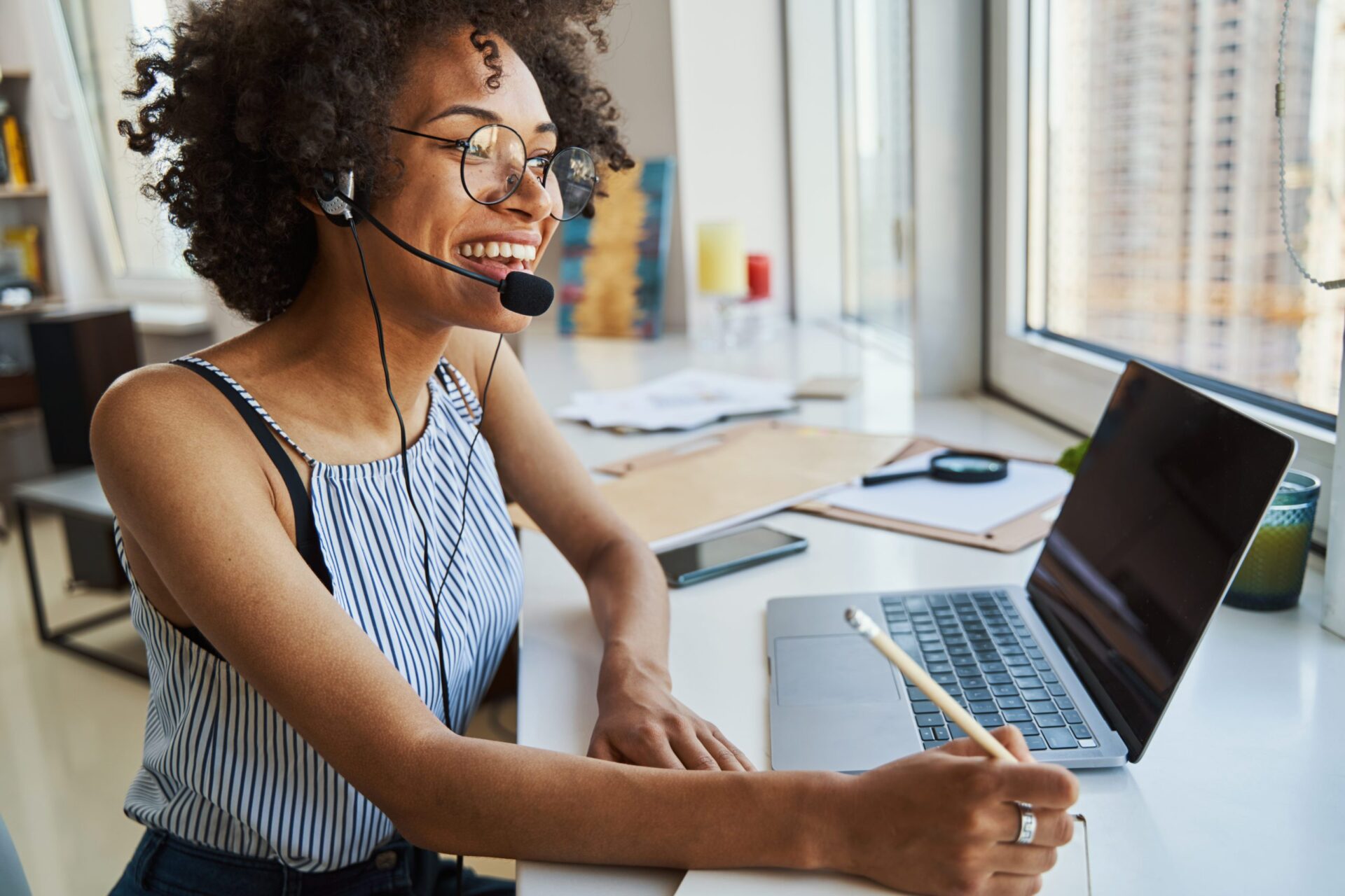 Joyous remote worker in the headset and eyeglasses Help your team reach its potential